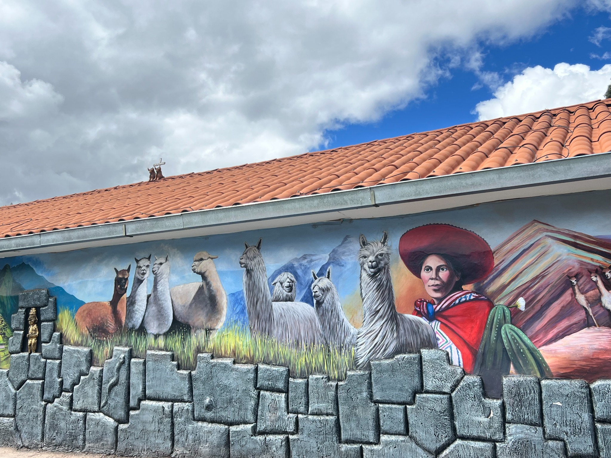 A colorful mural celebrating Peruvian culture and alpacas