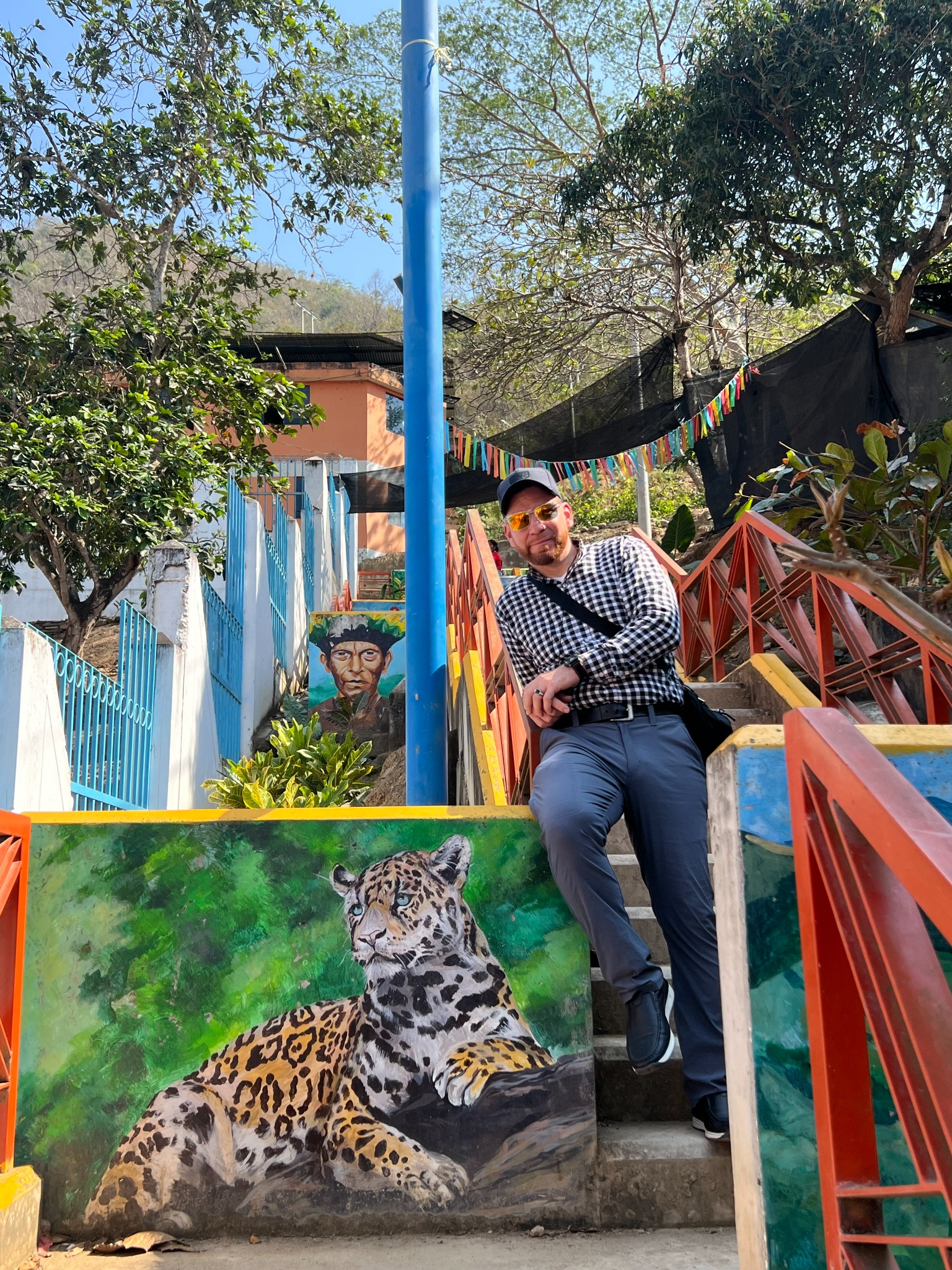 Jonathan sitting beside colorful public art in Peru